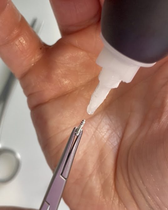une pointe de colle forte pour fixer les apprêts solidement