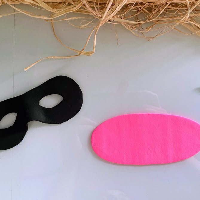 Masque légèrement séché ayant gardé sa forme, avec une plaque de foam clay rose vif à côté.