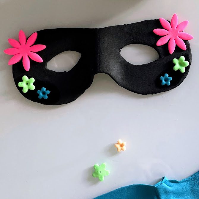 Masque terminé avec fleurs appliquées des deux côtés : rose en haut, verte au centre, bleue en bas.