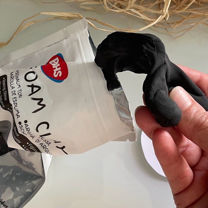 Main sortant un morceau de BOHS foam clay noire du sachet.